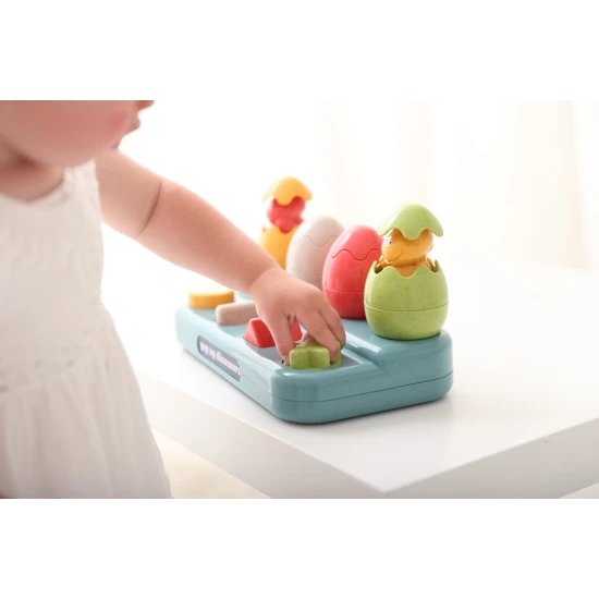 Einsteckbare Pop-up-Dinosaurier mit Knöpfen und Eiern, aus denen Dinosaurier herausspringen.