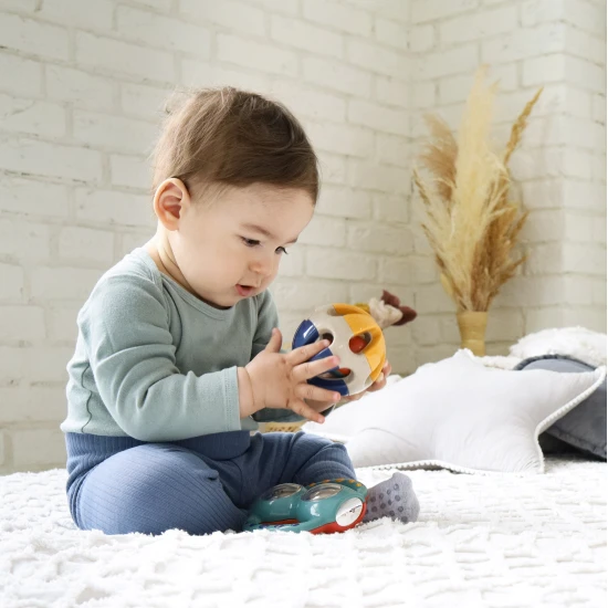 Bunte Rassel in Ballform mit Löchern zum einfachen Greifen in Babyhänden