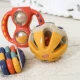 Bunte Rassel in Ballform mit Löchern zum einfachen Greifen in Babyhänden