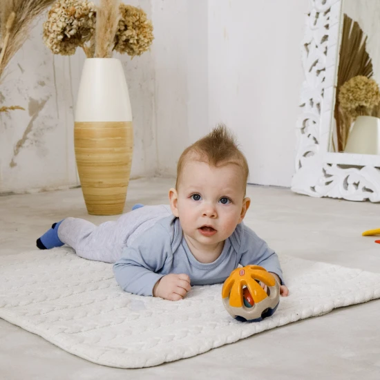 Bunte Rassel in Ballform mit Löchern zum einfachen Greifen in Babyhänden