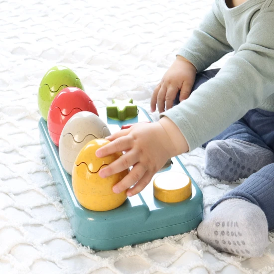 Einsteckbare Pop-up-Dinosaurier mit Knöpfen und Eiern, aus denen Dinosaurier herausspringen.