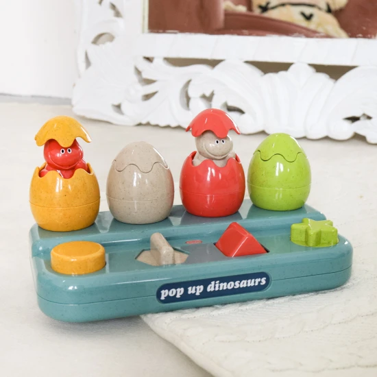Einsteckbare Pop-up-Dinosaurier mit Knöpfen und Eiern, aus denen Dinosaurier herausspringen.