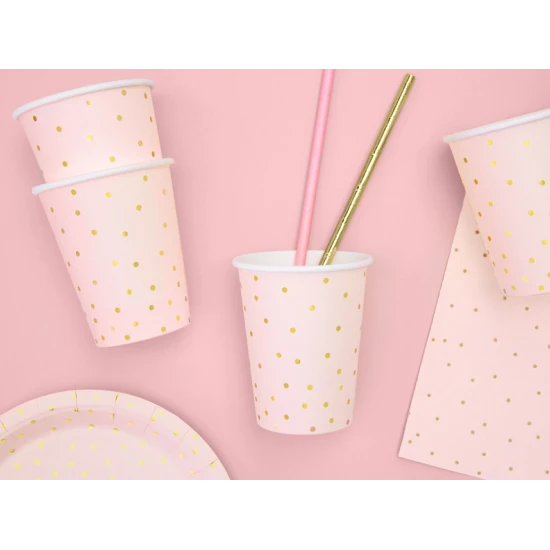 Gläser, die jede Party aufheitern. Rosa Pappbecher sind mit goldenen Punkten verziert.